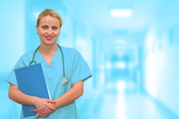 手拿病历夹的专业医生站在医院大厅的模糊背景前图片下载