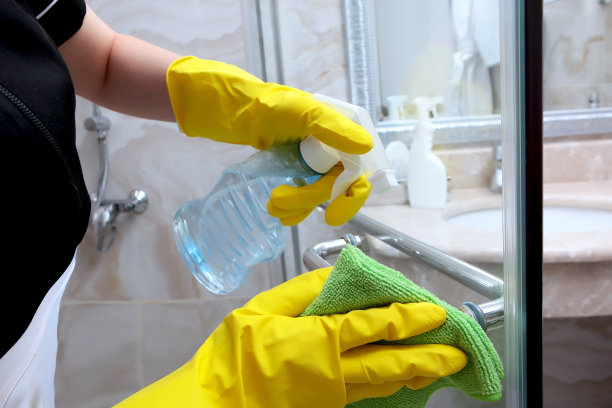 特写的手在橡胶手套清洁门把手在淋浴间。无法分辨的照片。清洁和卫生的概念。图片下载