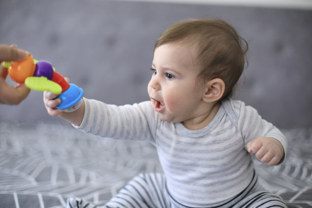 小女孩伸手去拿玩具图片下载