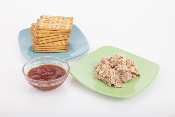 盐饼干和金枪鱼罐头;照片上的白色背景。图片下载