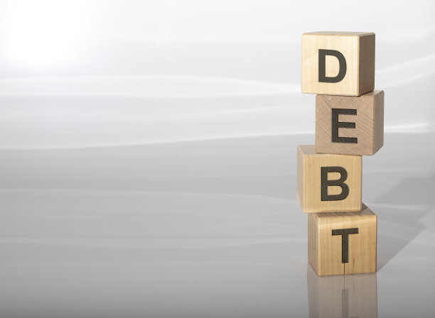 概念词债务木制立方体上的灰色背景与copyspace图片下载