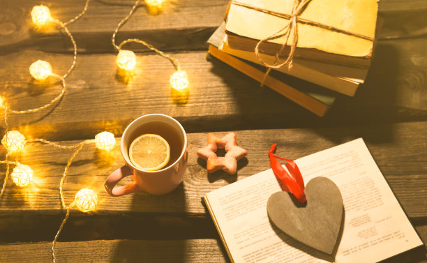 节日气氛的照片。圣诞彩灯和热茶杯。为舒适的夜晚订票。甜姜饼和木心放在托盘上。完美的冬季平躺。Hygge概念。图片下载