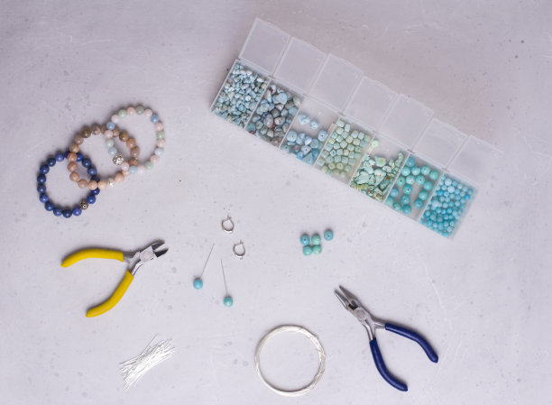 手工制作的珠宝。前视图。珠子，用来制作珠宝的工具。准备手工制作的。用你自己的双手，用天然宝石制作首饰、手镯。平的。在白色背景图片下载