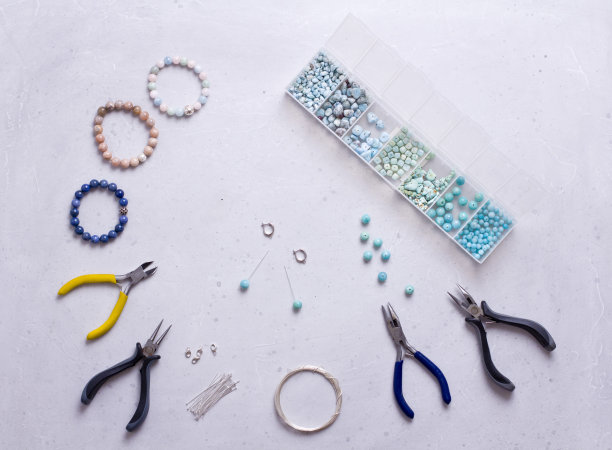 手工制作的珠宝。前视图。珠子，用来制作珠宝的工具。准备手工制作的。用你自己的双手，用天然宝石制作首饰、手镯。平的。在白色背景图片下载
