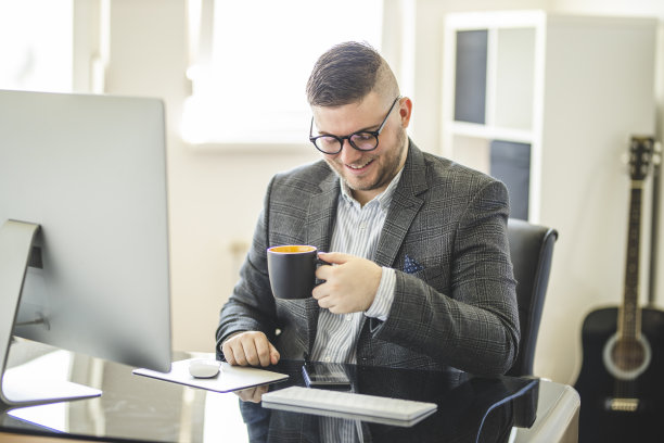 成功企业家在舒适的家庭办公室喝咖啡的肖像图片下载