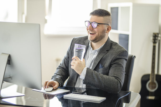 成功企业家在舒适的家庭办公室喝水的肖像图片下载