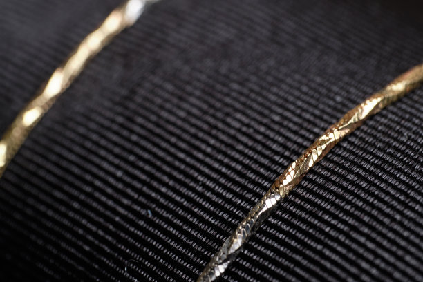 黑色布料上的金链。图片下载