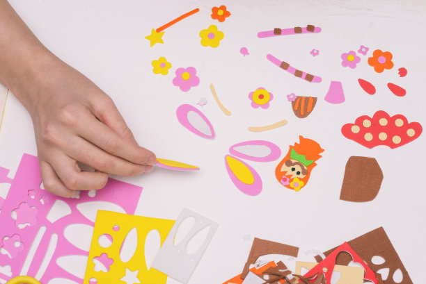 儿童应用多色纸。在工作场所工作。创建映射的详细信息。妇女用彩纸做手工艺品。幼儿园、夏令营或学校的艺术项目图片下载