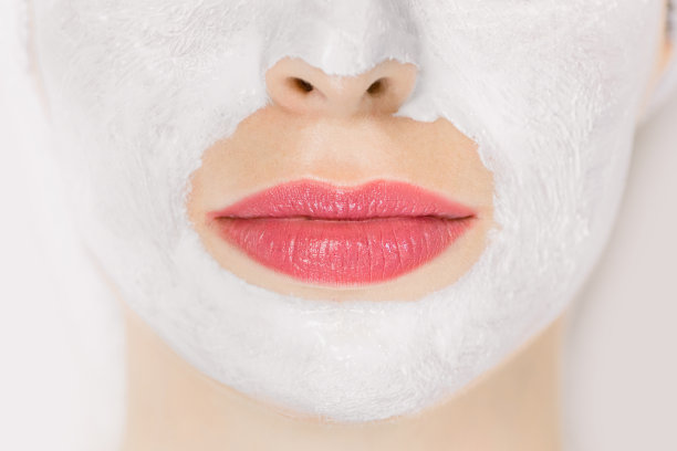 近距离微距照片底部的一个女人的脸与白色泥面膜的皮肤，细节视图。美容治疗。护肤品。面膜和美容图片下载