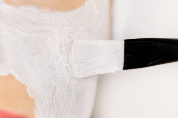 近距离微距照片，化妆师刷面部清洁泥粘土面膜在女人的脸，脸颊。美容护理、面膜、护肤理念、拷贝空间图片下载