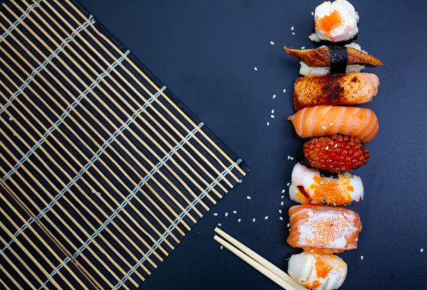 寿司，用筷子夹的生鱼片，日本寿司。图片下载