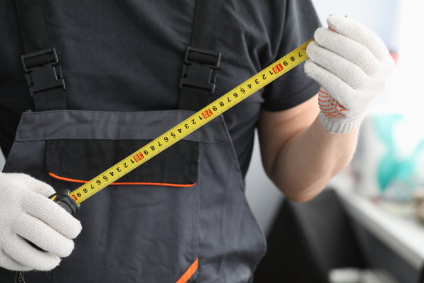 修理工在制服手套测量卷尺图片下载