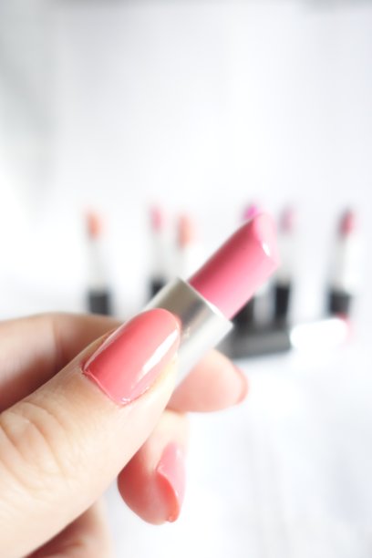 白底上的女人手拿着粉红色的口红图片下载