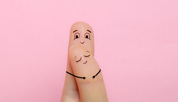 两根手指画着一对异性恋夫妇的脸，一男一女在粉红色的背景中微笑和高兴。没有人的爱和关系的概念图片下载