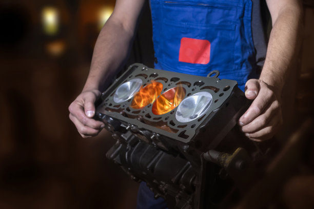在汽车修理厂工作的汽车修理工。发动机活塞上燃烧着火焰。维修服务。图片下载