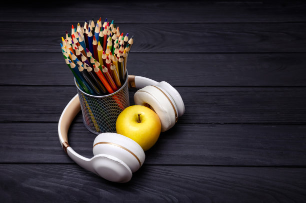黑色木质背景上的彩色铅笔和耳机。工作场所图片下载