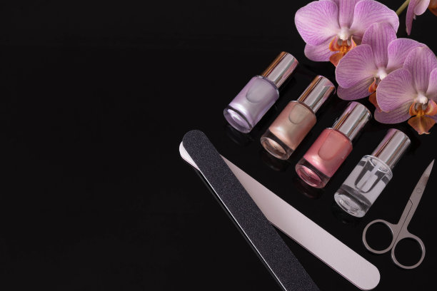桌上有指甲油、指甲锉、兰花和修指甲剪刀图片下载