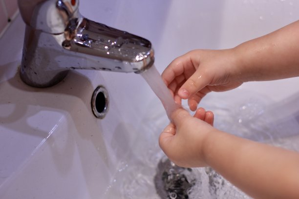 小男孩在水槽的水龙头下洗手。Сoncept卫生、疾病预防、病毒控制和应对新型冠状病毒感染的原始措施。有选择性的重点。图片下载