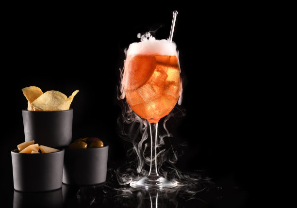 美丽的鸡尾酒孤立在黑色背景与干冰烟。图片下载