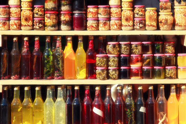 秋乡集市健康产品。自制葡萄酒，罐装坚果，架子上的瓶装酒精草药饮料。图片下载