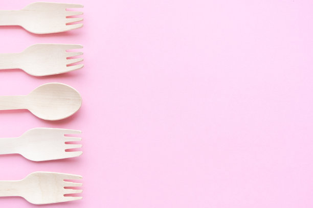 粉色背景的环保一次性厨具。木制的叉子和勺子。32、生态环保，零浪费理念。前视图。平的。copyspace图片下载