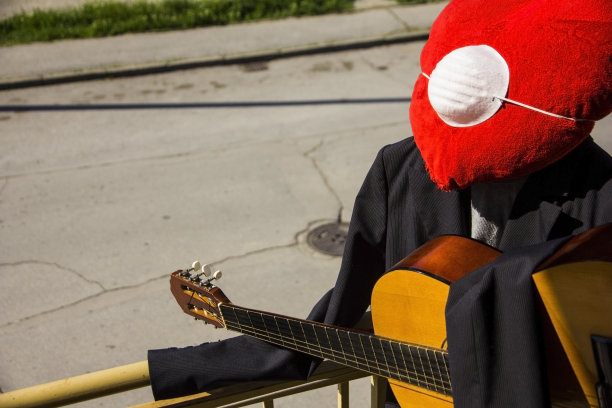 Covid-19,冠状病毒。病毒和毛绒心脏在家里使用医用口罩工作。吉他手，远方的爱，在隔离和隔离。弹吉他，待在家里，健康理念图片下载