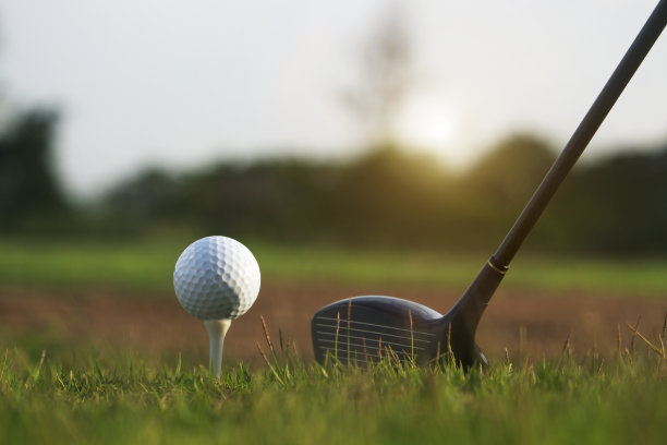 高尔夫球杆和高尔夫球在一个美丽的高尔夫球场的绿色草坪上图片下载