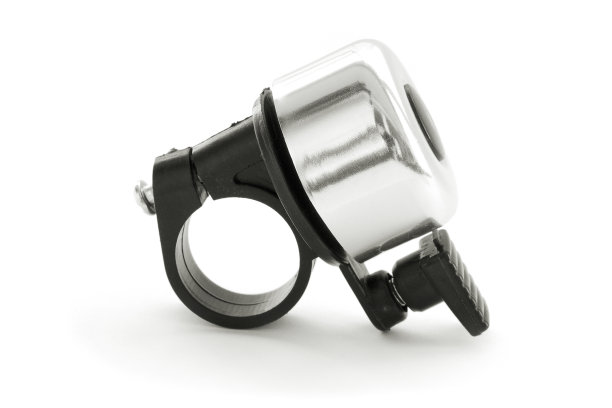 银色的自行车铃孤立在白色的背景上。自行车铃，塑料喷嘴与金属环部分带阴影。自行车铃在白色的背景和阴影。图片下载