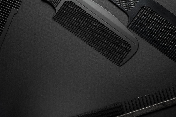 黑色的表面上是旧的理发师工具。梳子。黑色的单色。水平方向。俯视图平坦ley。图片下载