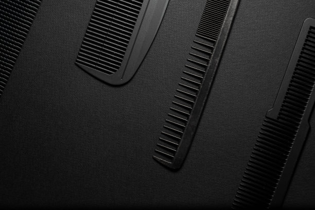 在黑色的表面上是旧的理发工具。理发工具。四个梳子。黑色的单色。框架。前视图。图片下载