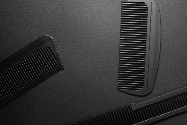 在黑色的表面上是旧的理发工具。理发工具。三个梳子。黑色的单色。框架。俯视图平坦lay。图片下载