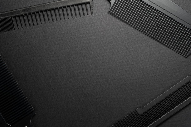 在黑色的表面上是旧的理发工具。理发工具。四个梳子。黑色的单色。框架。前视图。图片下载