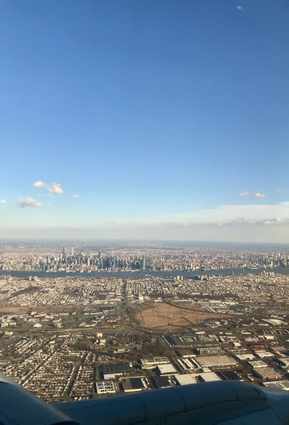 从飞机机翼窗口拍摄的国际旅行航拍照片:曼哈顿的天际线，美国著名的大都市，其高耸的摩天大楼为背景图片下载