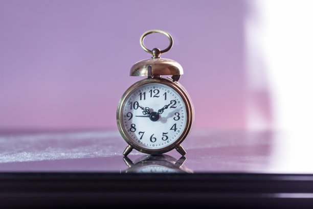 被早晨的太阳照亮的橱柜上的老式闹钟图片下载