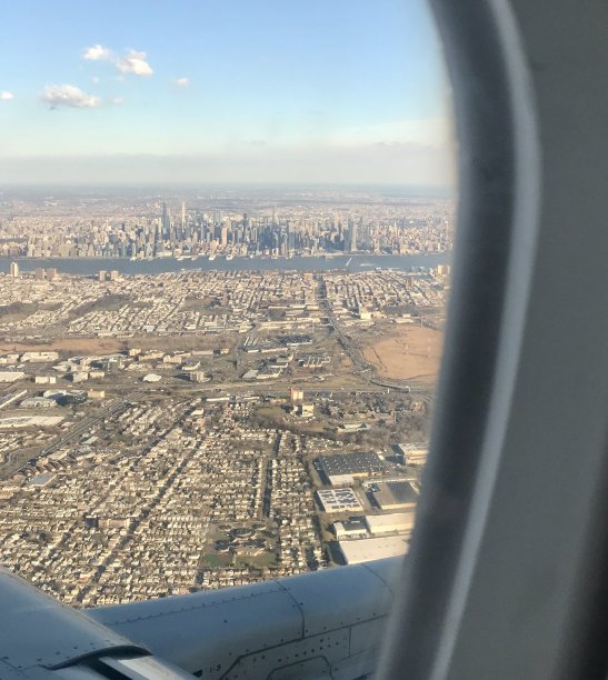从飞机窗户拍摄的美国航拍照片:风景如画的纽约市中心的交通枢纽和旅游景点，以摩天大楼为背景图片下载