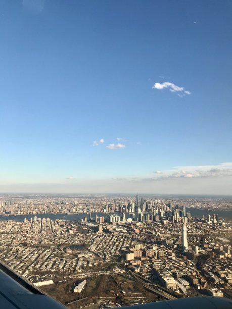 从飞机机翼窗口拍摄的国际旅行航拍照片:曼哈顿的天际线，美国著名的大都市，其高耸的摩天大楼为背景图片下载