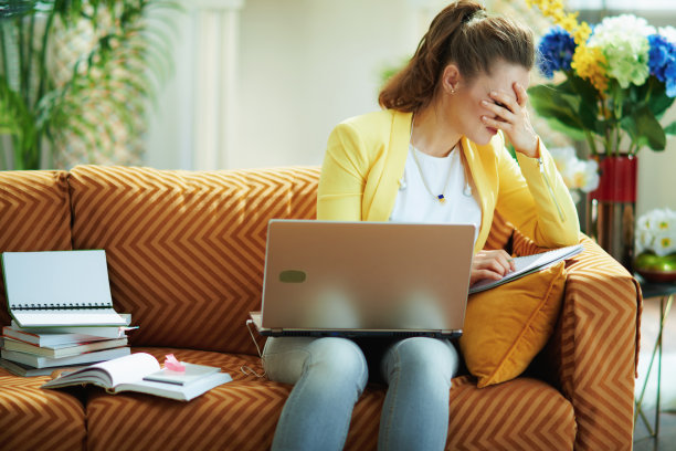压力大的女性在阳光明媚的日子里在现代客厅里在线学习图片下载