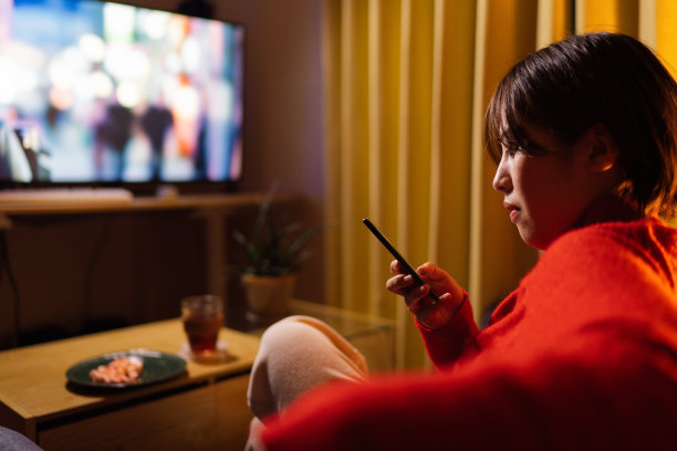 年轻女子晚上在家看电影图片下载