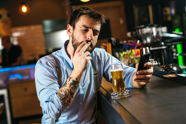 年轻的成年男性在酒吧喝酒图片下载