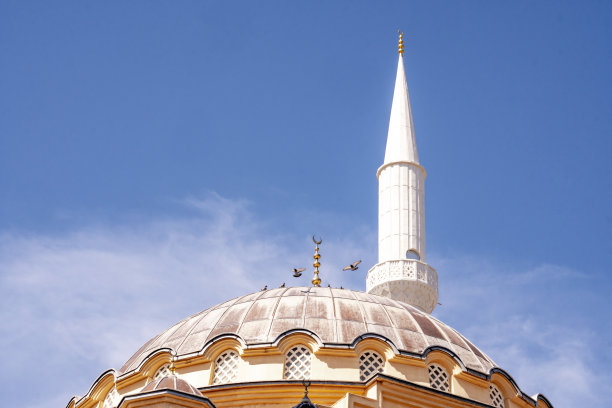 一个大清真寺的圆顶和塔在白天的光与蓝天夜晚的背景。斋月的概念。图片下载