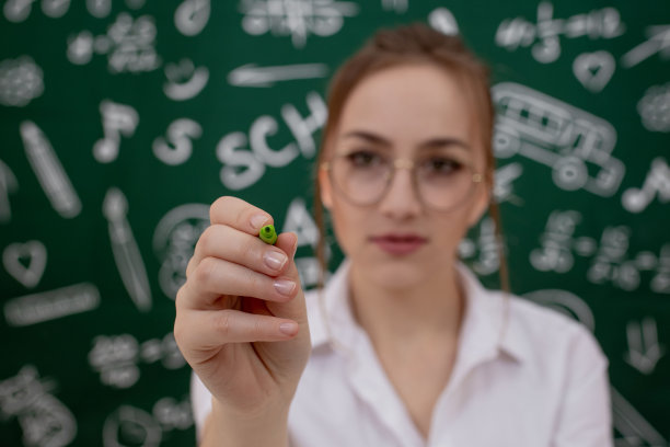 教育理念——以绿色书包、笔记本和学习用品为背景的黑板图片下载