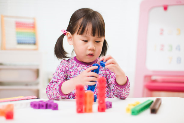 蹒跚学步的女孩玩数字积木在家上学图片下载