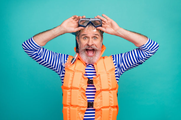 照片震惊疯狂的老水手海底呼吸管面罩兴奋的潜水员张开嘴穿着条纹水手衬衫橙色救生衣孤立的蓝绿色背景图片下载