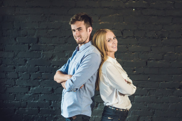 商业团队由男女青年商人组成，站在黑暗的背景下图片下载