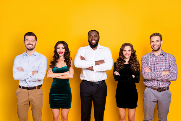 有吸引力的两个女人的照片，三个大男子多样性不同的种族公司的学生毕业晚会穿着得体的胳膊交叉愉快最好的朋友孤立的黄色背景图片下载