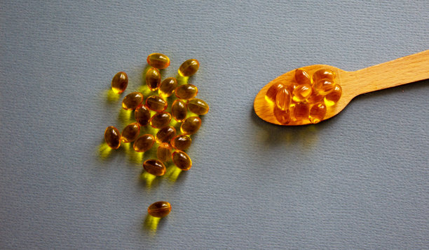 木勺药丸孤立在美丽的蓝色背景。网页横幅与复制空间。图片下载