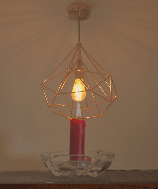 覆盖的灯具与一个灯泡点燃和蜡烛点燃的对比和悖论图片下载