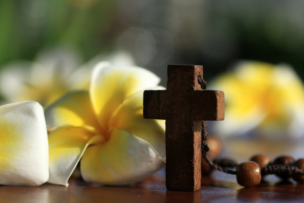 念珠与耶稣基督神圣的十字架和花接近。图片下载