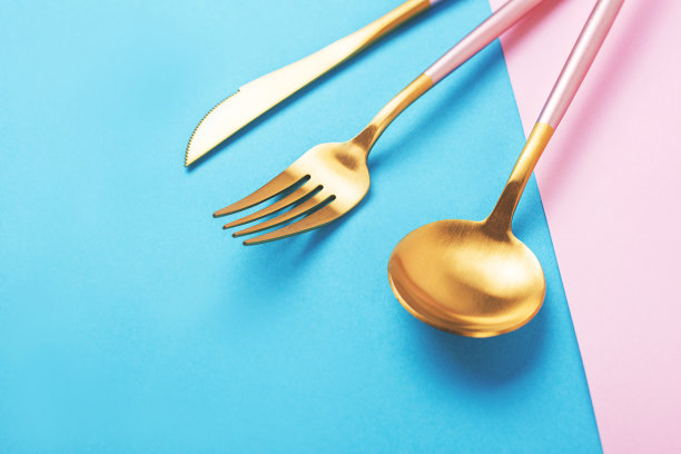 美丽的餐具设置在粉红色和蓝色的背景。图片下载