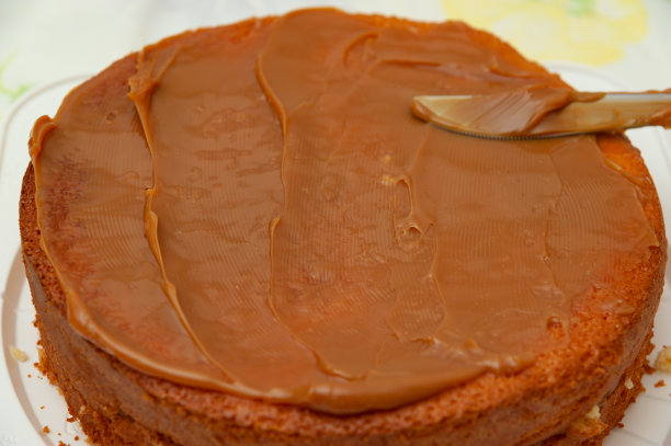 制作海绵蛋糕。用抹刀涂抹牛奶焦糖。特写镜头。图片下载